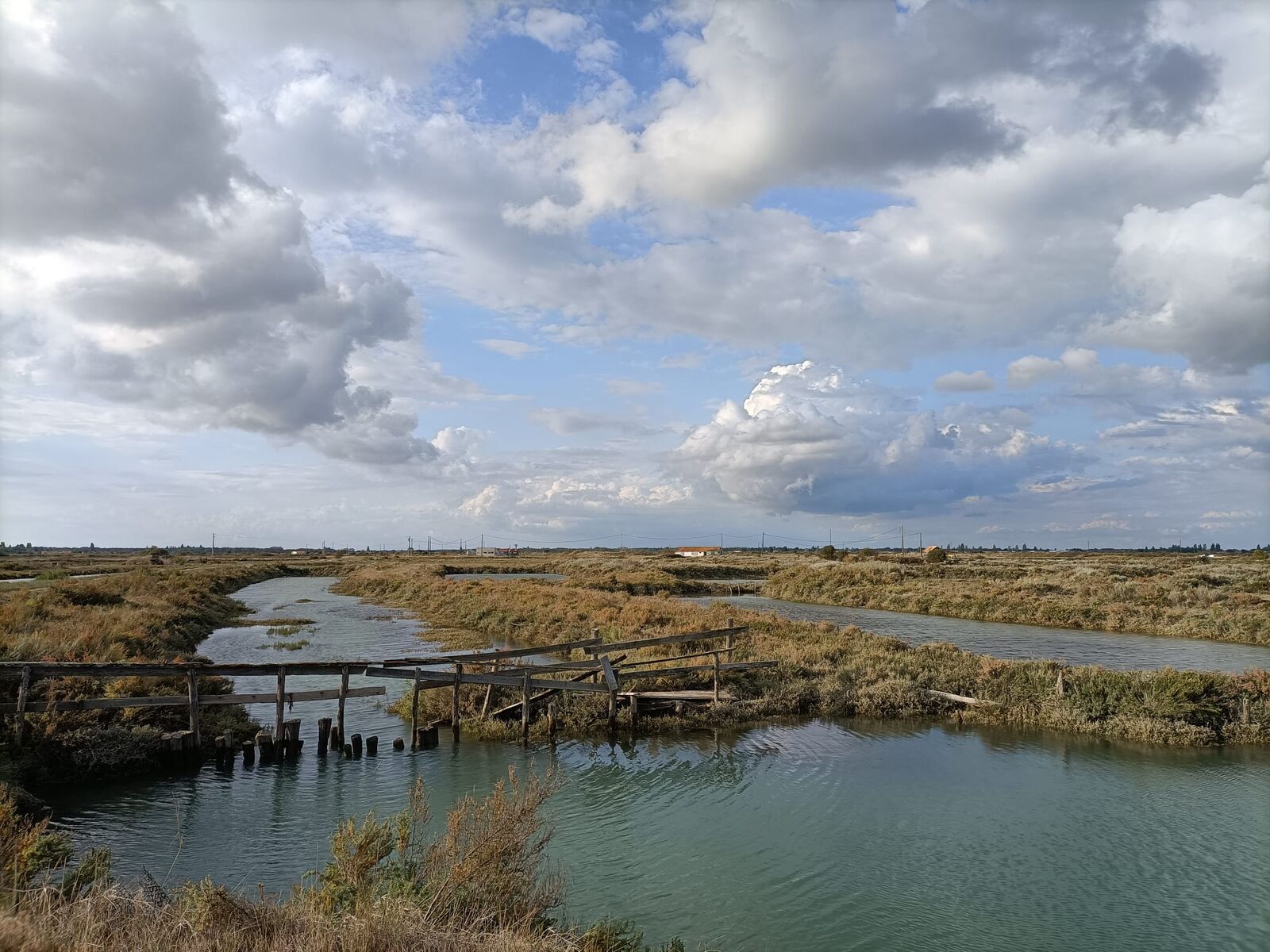 Les marais et leurs chenaux sous un ciel de nuages